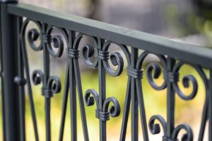 a gray wrought iron fence is a great addition to a home 